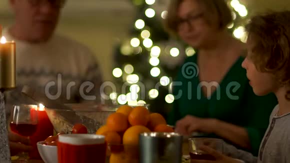 大家庭庆祝新年祖父和祖母和他们的孙子坐在桌子旁夹子眼镜视频的预览图
