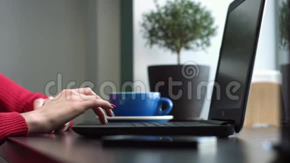 女手在咖啡厅的笔记本电脑上工作视频的预览图