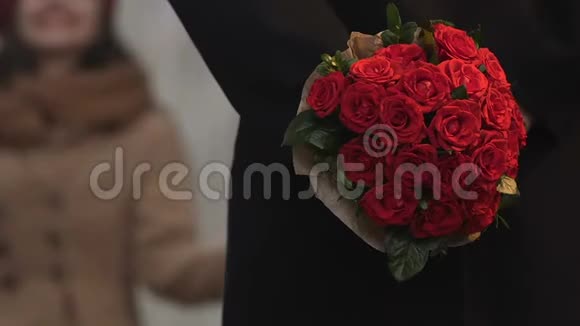 布鲁内特女孩约会迟到了男人拿着花等待把花束送给女人视频的预览图