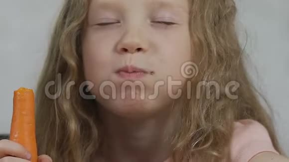 热情的孩子快乐地嚼着胡萝卜咬着健康的松脆蔬菜视频的预览图
