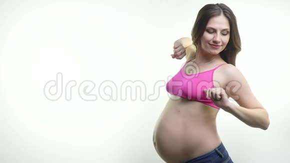 一位黑发孕妇站在白色背景下正在接受训练视频的预览图