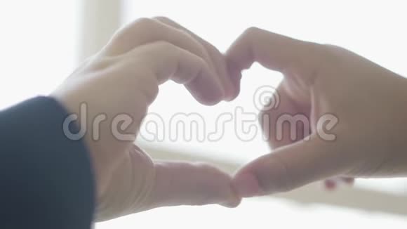 可爱的孩子们用手指靠近来描绘心脏的形状由儿童手塑造的心脏爱情友谊的概念视频的预览图
