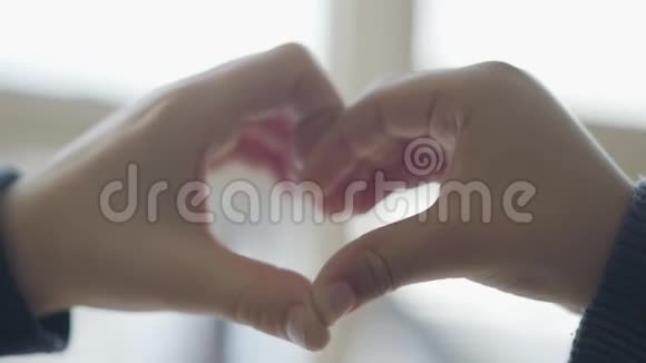 孩子双手合拢形成的心脏可爱的孩子们用手指描绘心脏的形状爱情友谊的概念视频的预览图