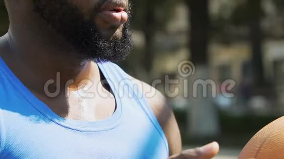 集中精力的黑人男子叹了口气准备在篮球场上投掷运动视频的预览图