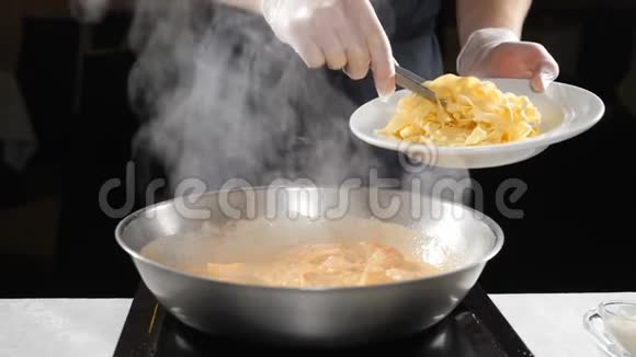准备食物在餐馆做意大利面带手套的厨师把意大利面放进煎锅里用厨房钳子慢动作视频的预览图