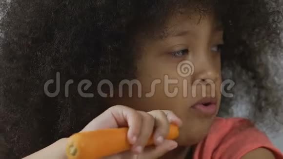 可爱的学龄前儿童咬新鲜的生胡萝卜每天的维生素营养视频的预览图