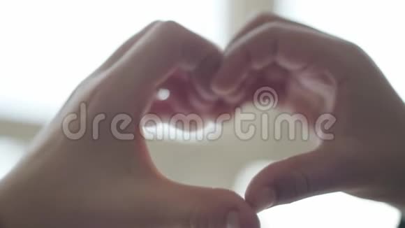 由儿童手塑造的心脏可爱的孩子们用手指靠近来描绘心脏的形状爱情友谊的概念视频的预览图