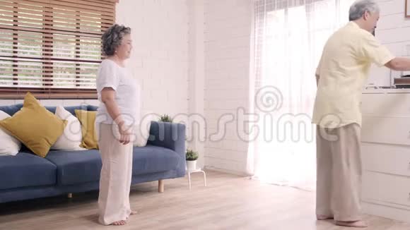 亚洲老年夫妇在家客厅听音乐时一起跳舞视频的预览图