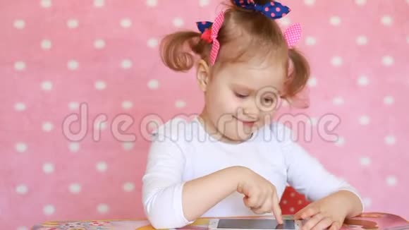 小女孩触摸智能手机的触摸屏并加载应用程序视频的预览图