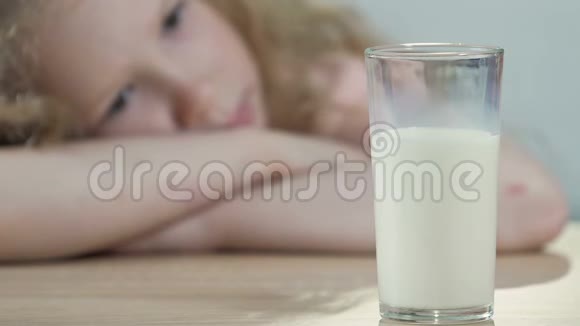 不耐乳糖的孩子伤心地看着一杯新鲜的白牛奶营养视频的预览图