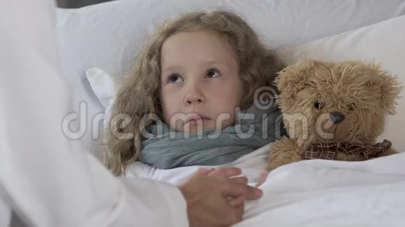 烦躁的小女孩躺在床上体温高看着医生视频的预览图