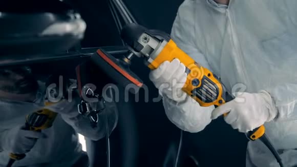 一个人在擦车修理工使用抛光设备在车库工作视频的预览图