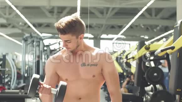 有魅力的运动员在健身房锻炼哑铃视频的预览图