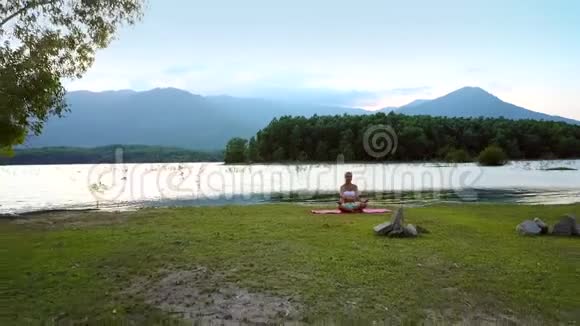 远观女孩改变湖岸瑜伽姿势视频的预览图