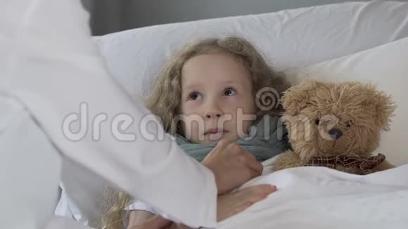 可爱的金发孩子躺在床上医生用听诊器检查女孩特写视频的预览图