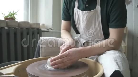 一个年轻的陶工在陶工的车轮上工作视频的预览图