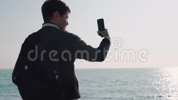 人的后视角是白天用智能手机拍摄海洋视频视频的预览图