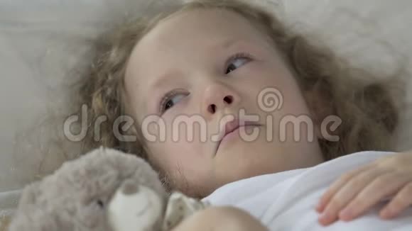 生病的金发女孩躺在医院病房的床上哭泣医疗保健视频的预览图