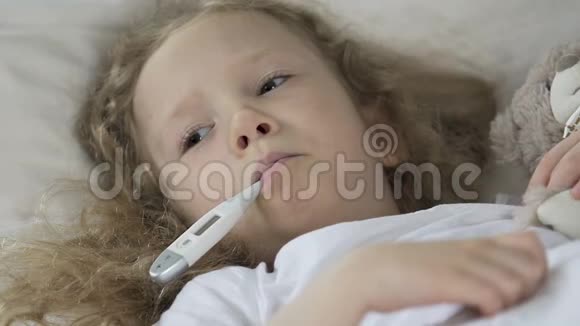 小病女孩躺在床上嘴里放着体温计视频的预览图