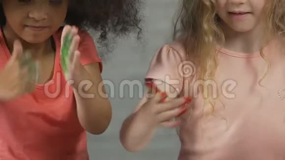 两个可爱的孩子用五颜六色的油漆盖住小手产品对孩子来说是安全的视频的预览图