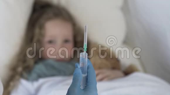 害怕的女孩子躺在床上看着巨大的注射器和疫苗视频的预览图