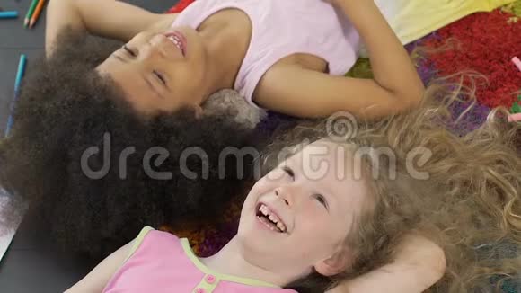 两个爱笑的孩子躺在地上玩得很开心很开心视频的预览图