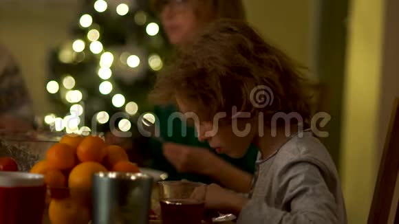 一个十几岁的男孩吃了一条鸡腿擦掉了袖子家庭圣诞晚餐礼仪规则在视频的预览图