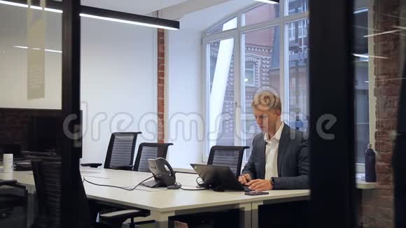 坚实的商人在办公室里独自在笔记本电脑前工作视频的预览图