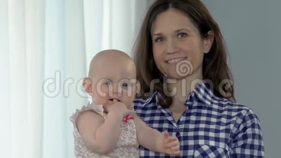 微笑的女人抱着女婴孩子吮指快乐的母性和谐视频的预览图