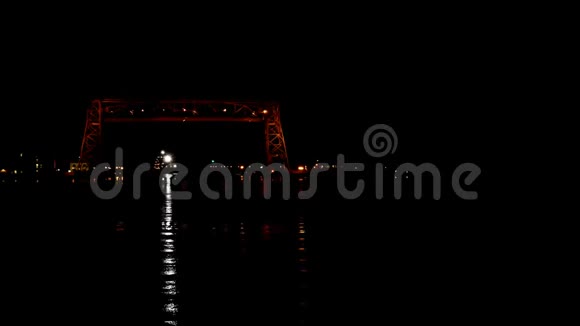 一艘铁矿石船在历史悠久的Duluth空中升降桥下驶来视频的预览图