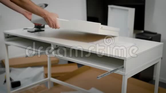 一个修理工把白色桌子组装起来的特写镜头视频的预览图