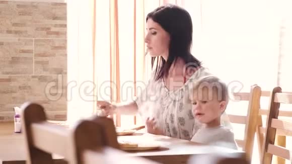 一位有爱心的母亲试图喂养她的孩子她一失败就自己吃东西视频的预览图