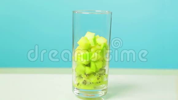 在一个玻璃玻璃片中切下一个猕猴桃和苹果的水果片玻璃旋转成圆视频的预览图