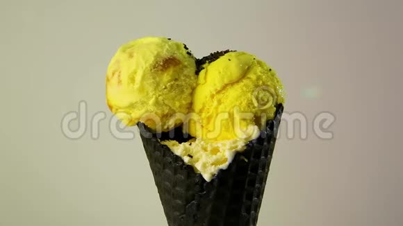 在巧克力华夫饼杯中加入黄色的冰淇淋并撒上干巧克力和碎果仁视频的预览图