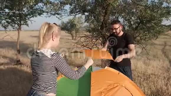 一对夫妇巧妙地搭起帐篷然后拍手在工作结束后向自己打招呼视频的预览图