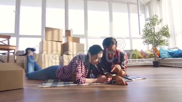 年轻夫妇躺在地板上背景是搬家用的箱子视频的预览图