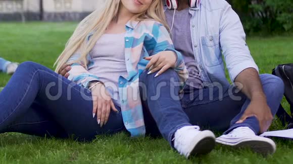年轻夫妇坐在草地上女孩靠在男人身上关系视频的预览图