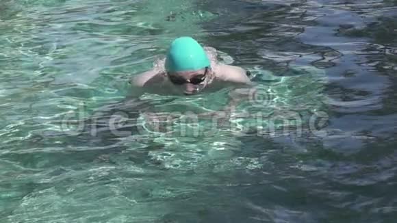 这位年轻的运动员在游泳池里漂浮着一只胸蝴蝶在相机上缓慢地移动着视频的预览图