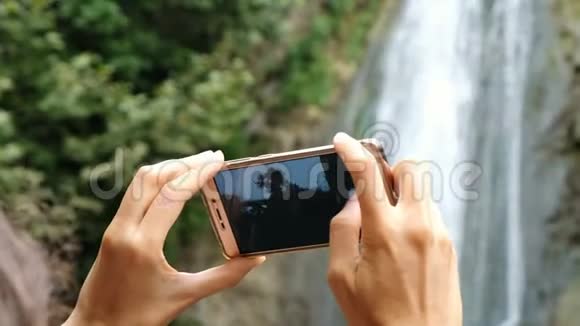 女人在拍瀑布智能手机视频的预览图