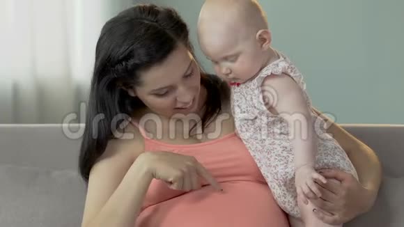 孕妇抱着婴儿指着肚子婴儿往下看视频的预览图