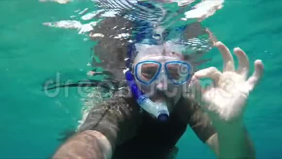 潜水员潜入水中并使OK标志视频的预览图