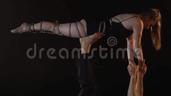 一个被绳子绑着的女人在男人的腿上表演杂技慢动作视频的预览图