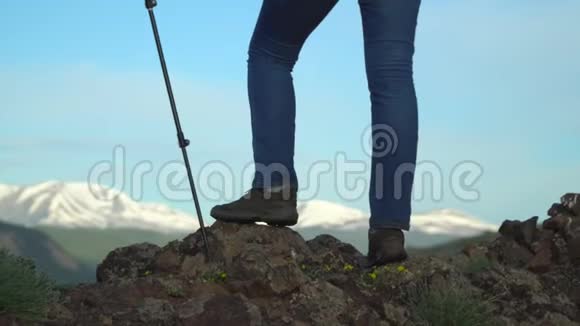 旅行者的女人用棍子在山坡上追踪基本上是腿慢镜头视频的预览图