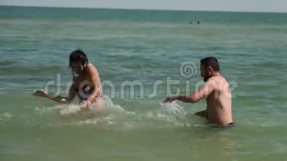 一对夫妇在海水中玩耍他们互相残杀然后年轻人放弃掉进水里视频的预览图