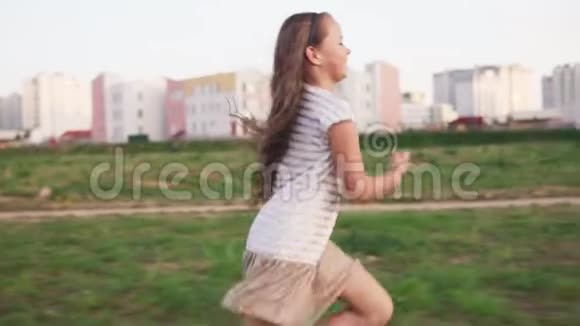 夏日里有趣的小女孩在城市草坪上奔跑视频的预览图