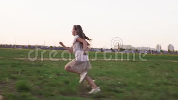 夏天快乐的小女孩在城市草坪上奔跑视频的预览图