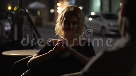 美丽的女性坐在餐厅和男人聊天晚上视频的预览图