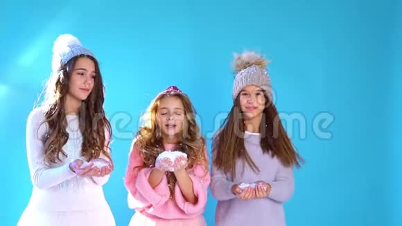 三个戴帽子的漂亮女孩在雪地里玩耍视频的预览图