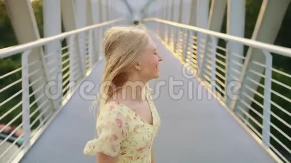 女人在桥上乱扔头发从后景中看到金发女人在人行桥上奔跑呕吐的头发视频的预览图