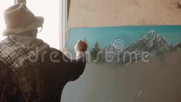 熟练的艺术家用画笔和染料在画中描绘松树后视视频的预览图